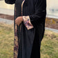 Abaya noire velours brodé motifs floraux vue de face — mode modeste élégante - Naqî Collection