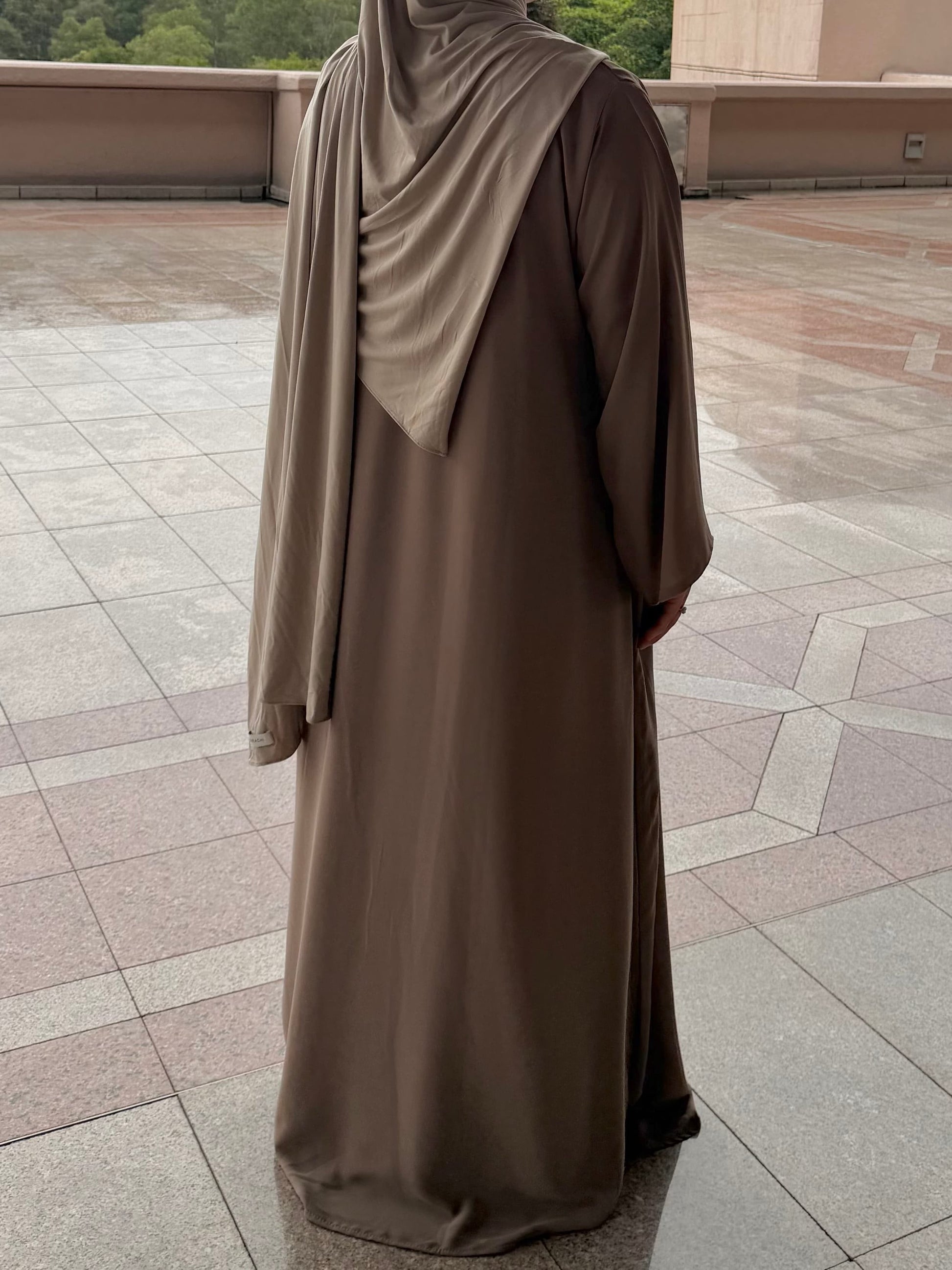 Abaya longue couleur taupe coupe évasée et fluide vue de dos  — mode modeste confort quotidien femme